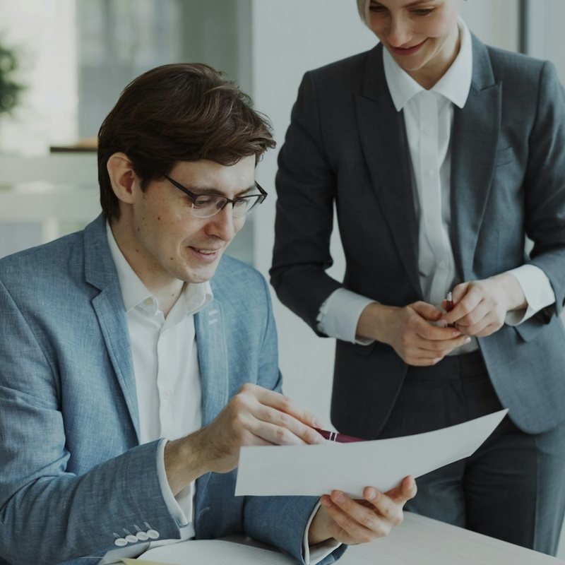 Two insurance professionals reviewing a document together in a modern office.